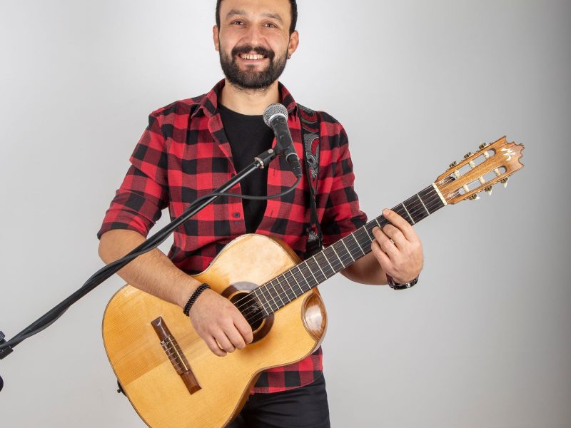 Smiling soloist with guitar and microphone
