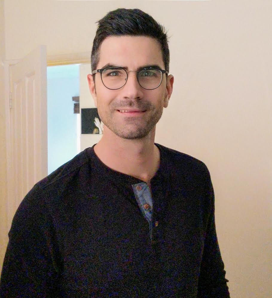 Dale Sutton smiling, wearing glasses and a dark shirt